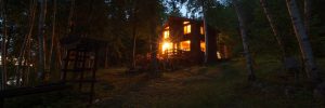 Brightly lit cottage windows at dusk